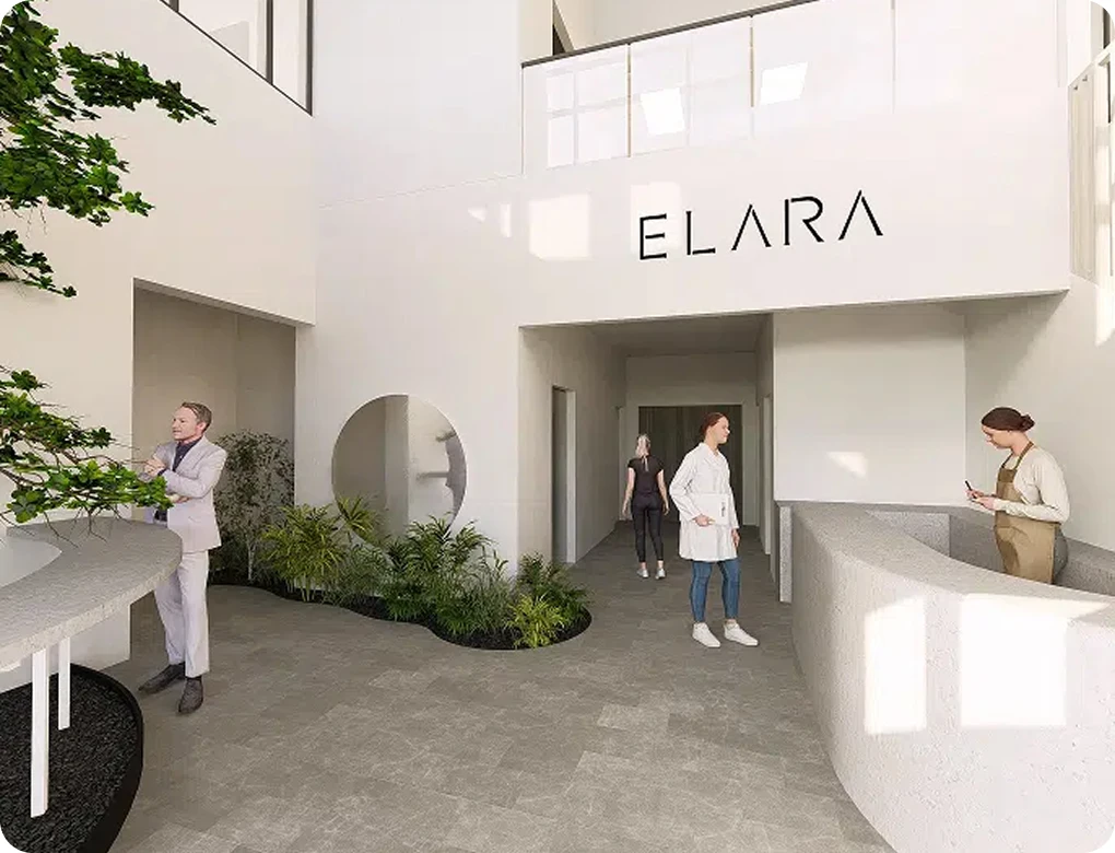 A bright, open-concept medical office lobby with the name "ELARA" displayed on the wall. The space is clean and modern, featuring white walls, stone flooring, and several people in professional attire.