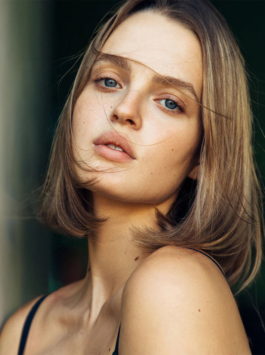A close-up portrait of a woman with a bob haircut and clear skin. The soft, natural lighting emphasizes her smooth forehead, plump lips, and refreshed facial appearance. - Injectables in Arizona