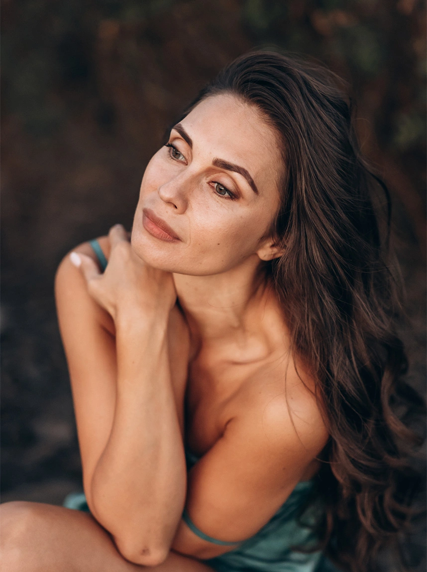 A portrait of a woman looking upward, featuring firm, well-positioned lower eyelids and a bright, rejuvenated expression in a natural outdoor setting. - Lower Eyelid Retraction in Arizona