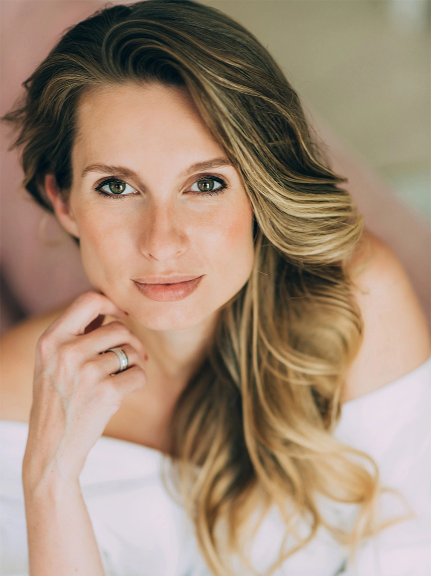 A close-up portrait of a woman with long blonde hair and green eyes. She looks directly at the camera with a clear, even skin texture and a soft, confident expression. - Scar Removal in Arizona