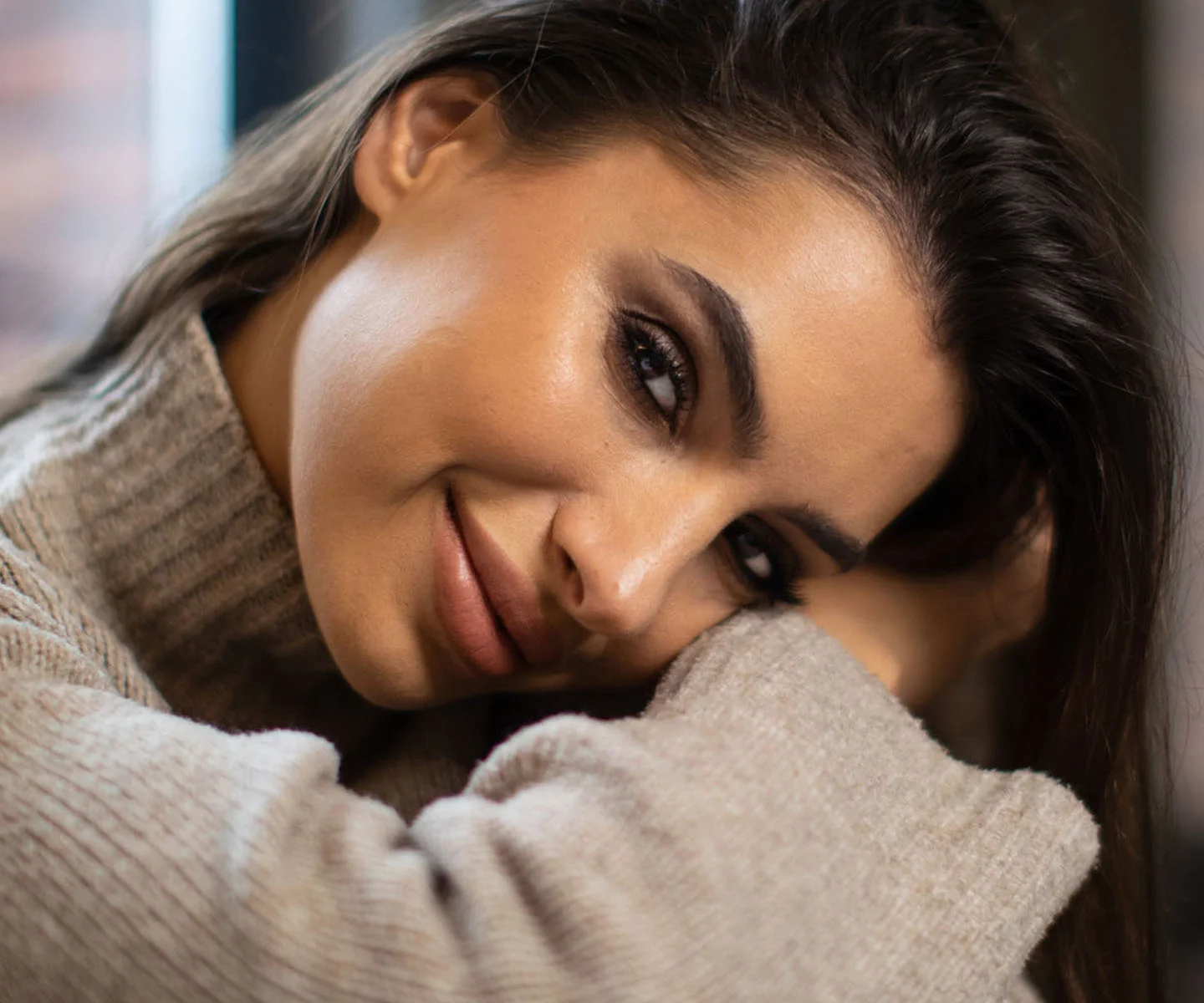 A focused portrait of a woman’s face from the nose up, emphasizing the forehead and eye area. Her eyes are bright and open, looking directly at the camera with a refreshed and youthful expression. The lighting is even and flatters the smooth texture of the skin, set against a neutral, out-of-focus background that conveys a sense of clarity. - Brow lift in Arizona